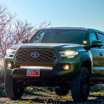 heretic's ba-2 pod light mounted as ditch lights on a toyota tacoma